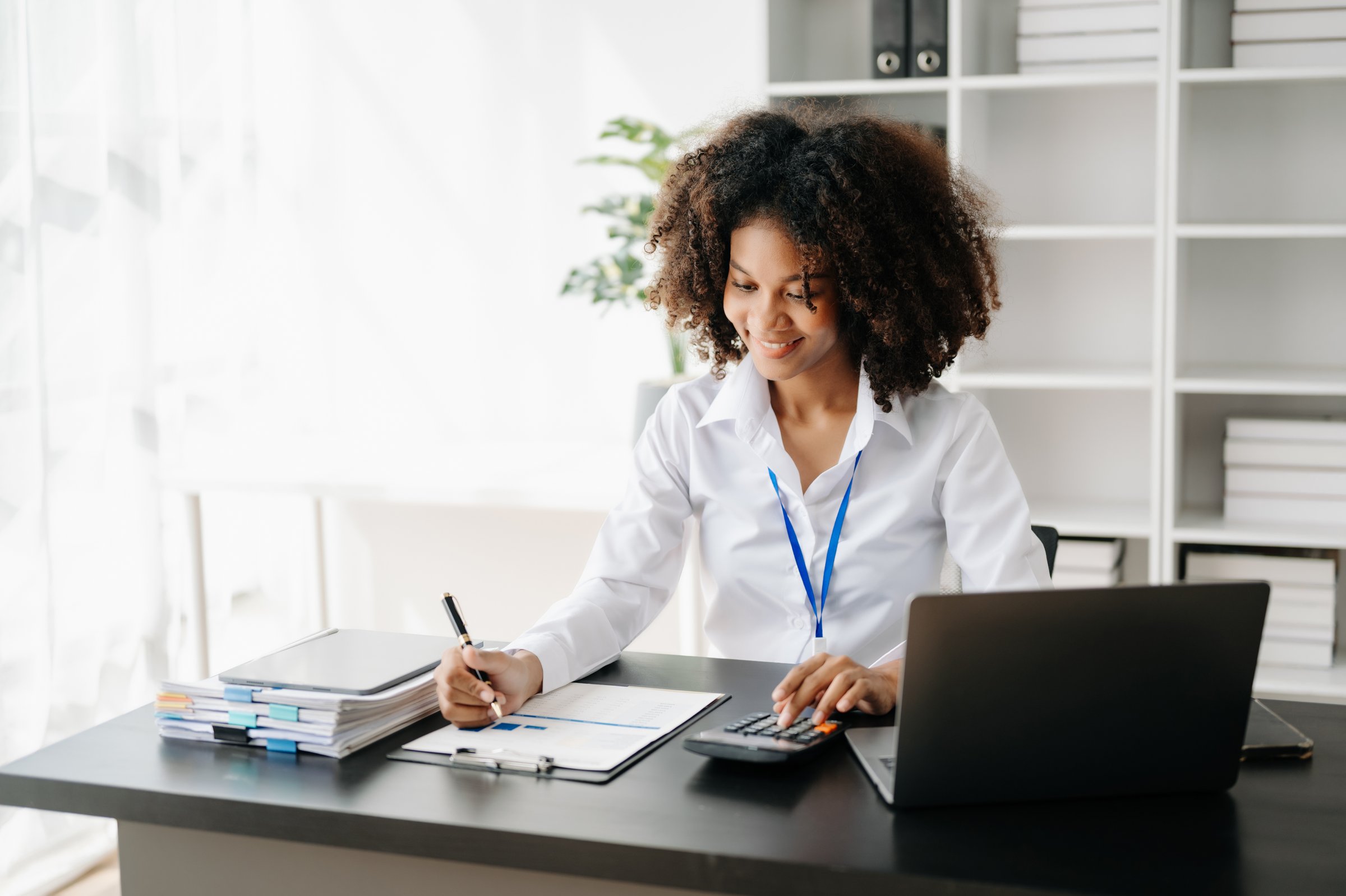 Business woman using tablet and laptop for doing math finance on an office desk, tax, report, accounting, statistics, and analytical research concept in modern office