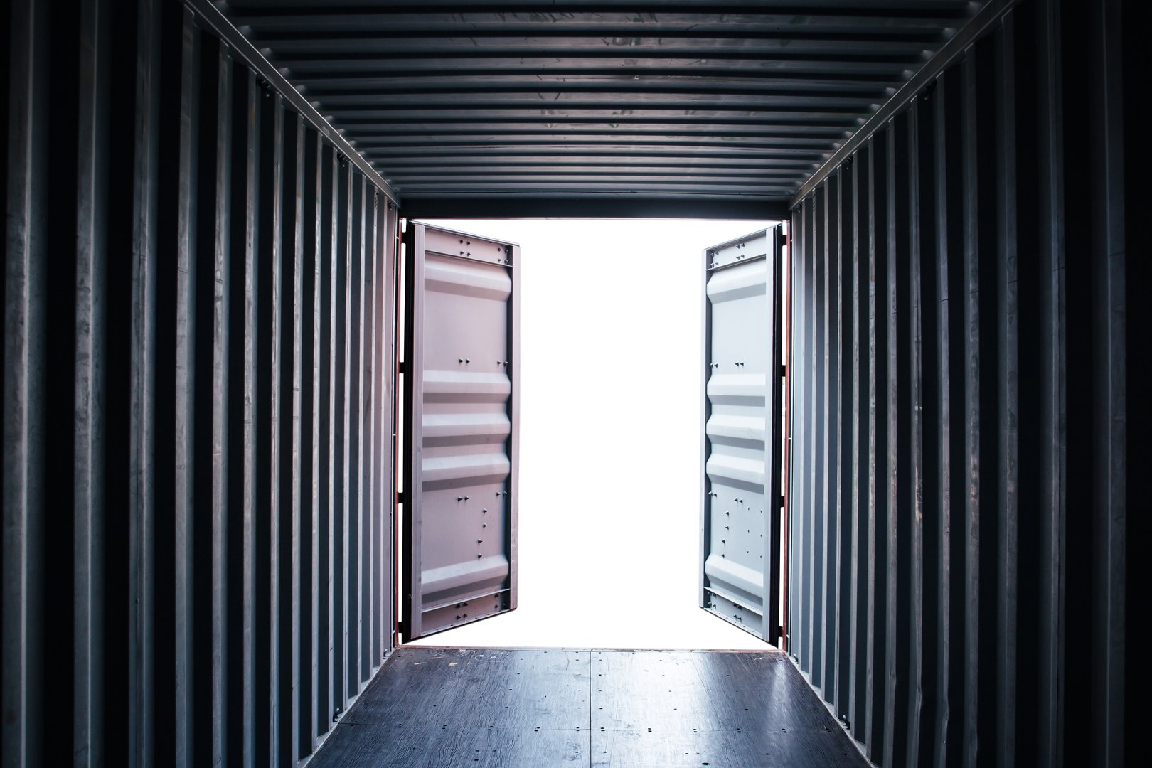 A photograph from inside a shipping container with its doors open.