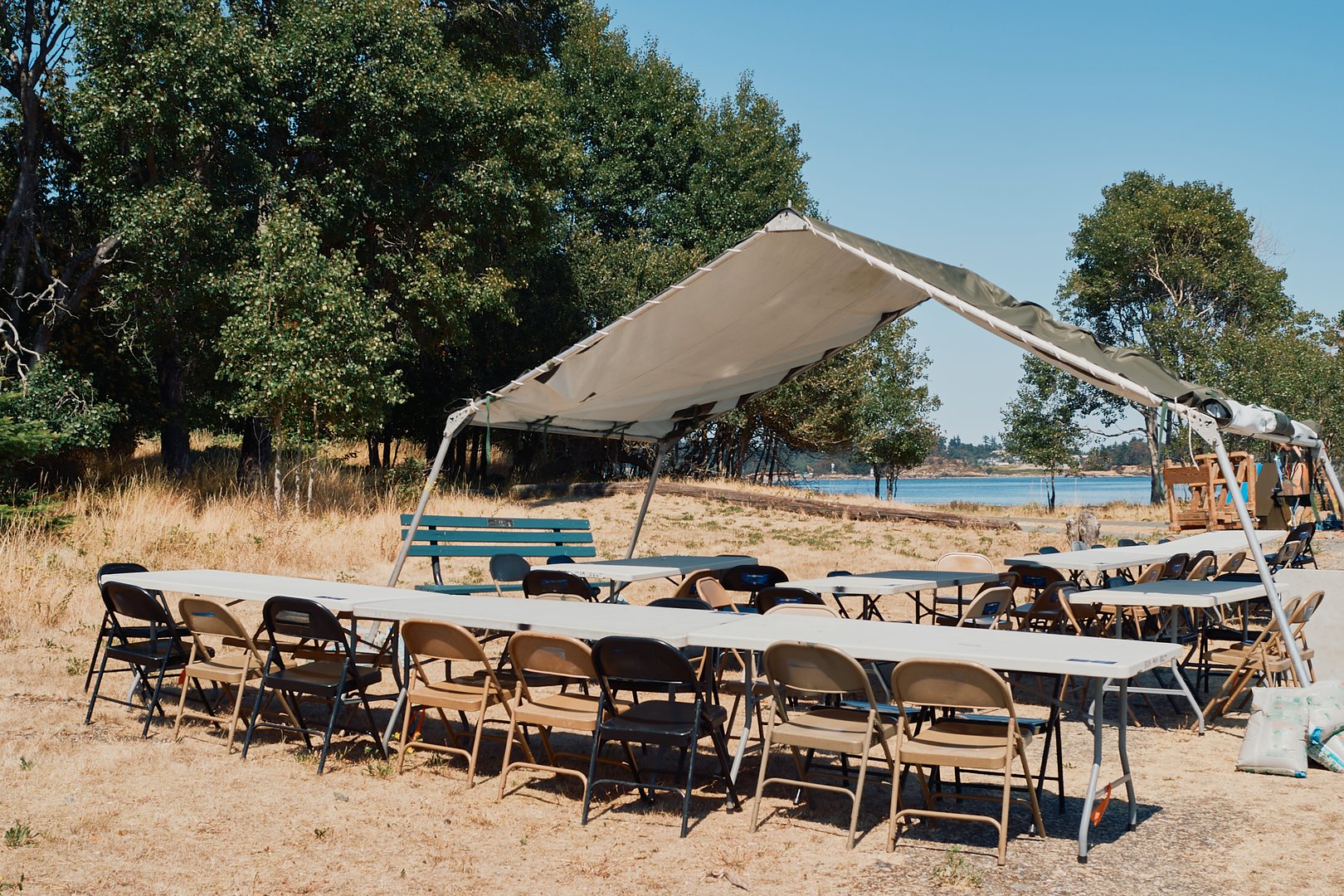 Event rental setup with tables and chairs under tent