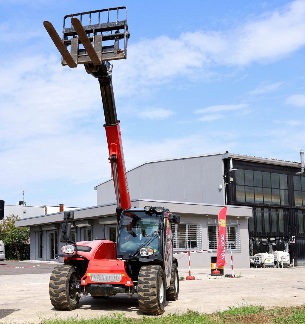 Tricesimo, Italy. July, 13 2025. Red telescopic handler Manitou with forklift attachment outside the dealership