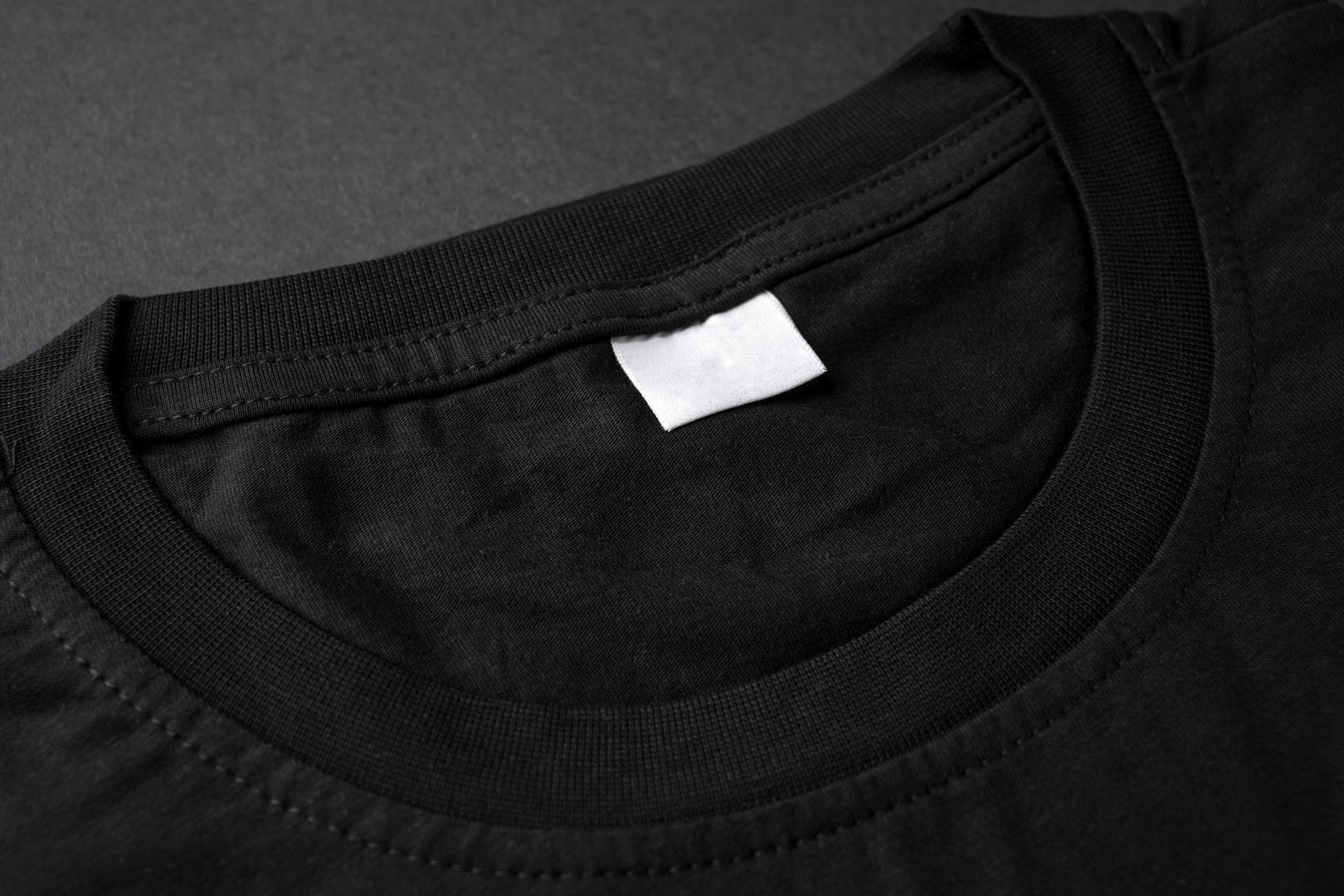 Close-up of black t-shirt collar with blank white label tag