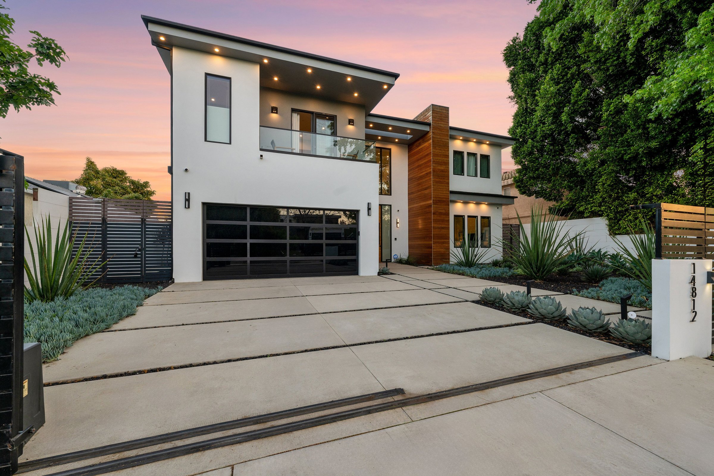 Twilight photo of a modern luxury home with pool, patio, and sleek architectural lines in a suburban setting