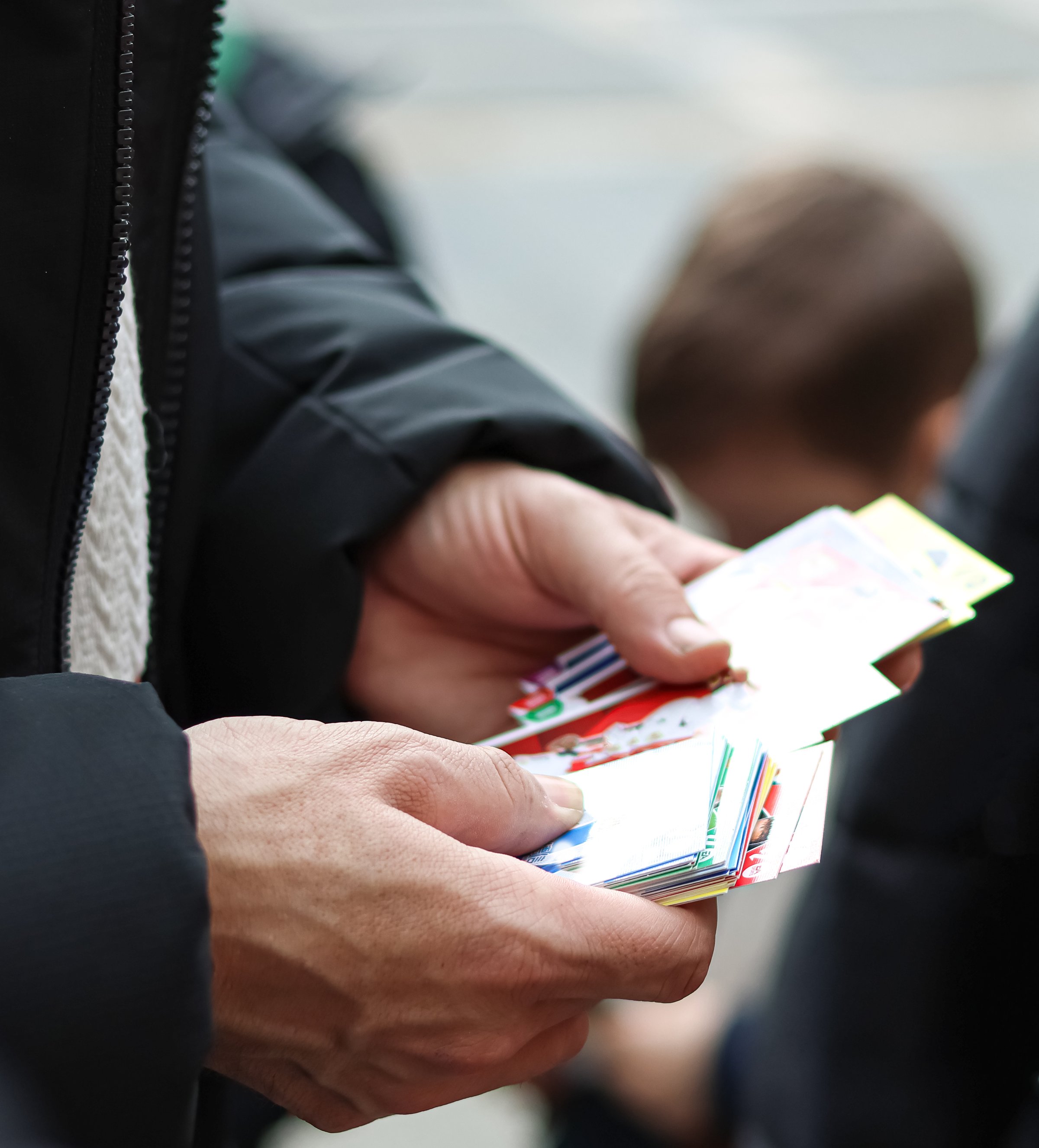 A father helping his children trade cards