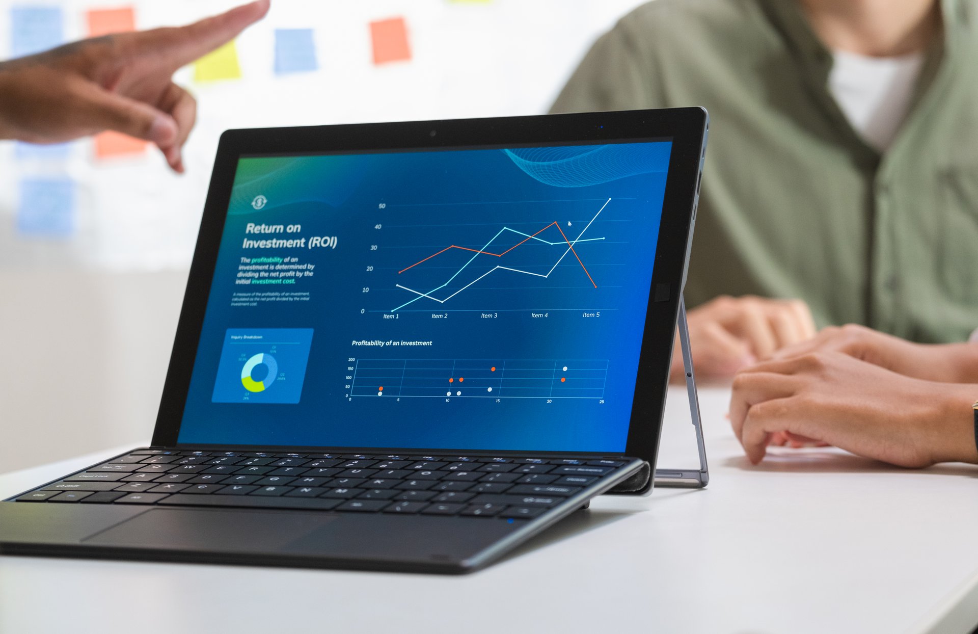 laptop when present  business presentation in a dimly lit office, analyzing financial charts and data projections on a screen