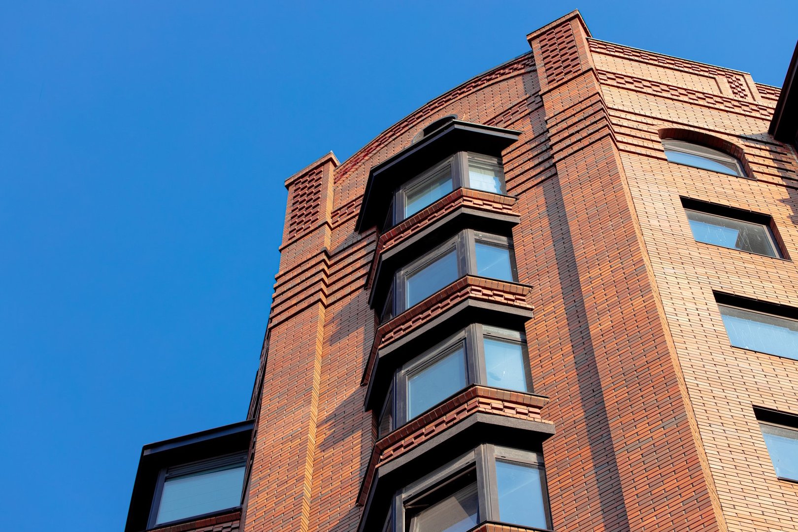 loft brick skyscraper modern building old school architecture style design external outdoor exterior facade foreshortening from below with empty blue sky background space