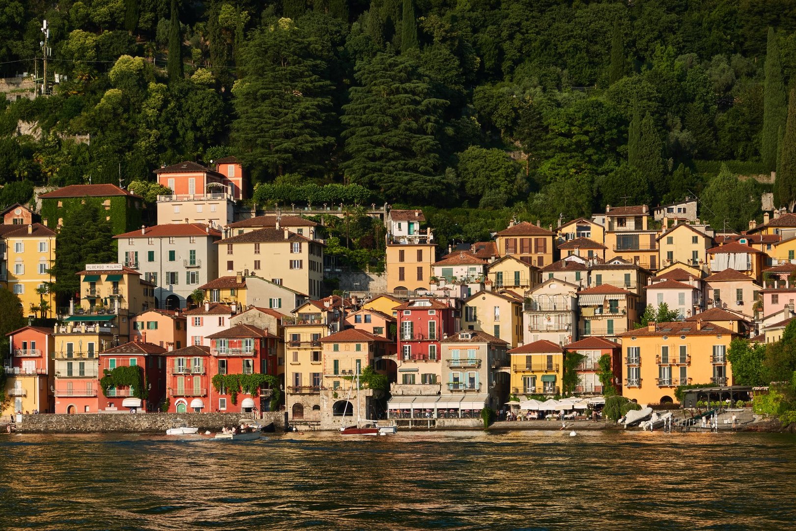 Picturesque landscape of Lake Como with luxury villas and colorful villages nestled against the Italian Alps under a blue sky