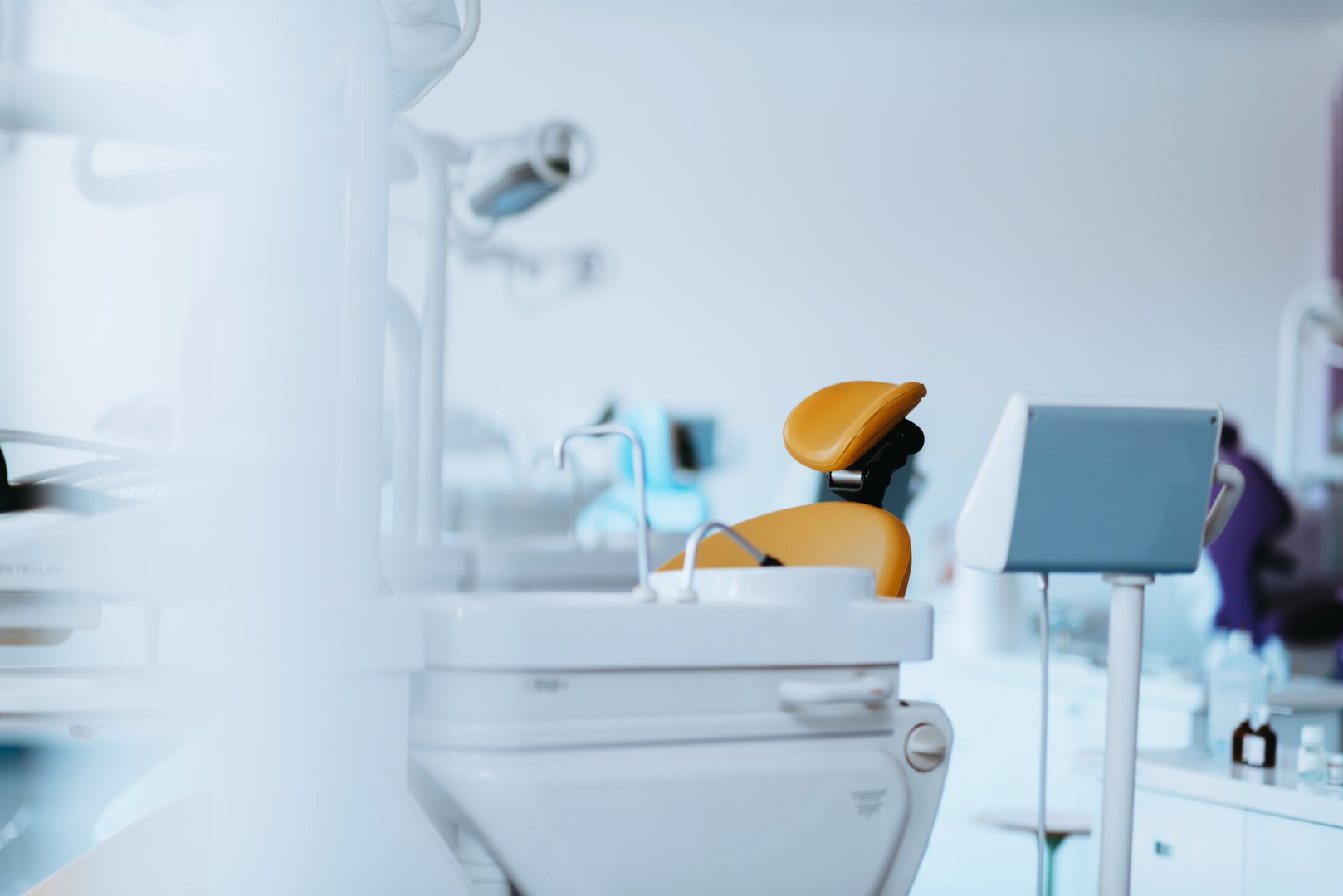 A bright and minimalist dental clinic with a sterile and sophisticated design. The well-lit, organized environment ensures a welcoming and professional atmosphere for patients, emphasizing hygiene and advanced dental care.