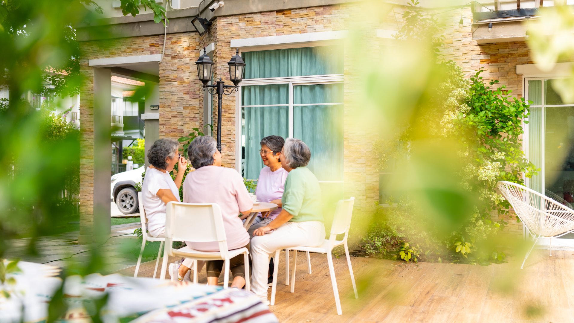 Group of Happy Asian senior mature women relax and enjoy indoor lifestyle meeting party together at home. Elderly retired woman friends drinking tea with talking together in the garden in summer day.