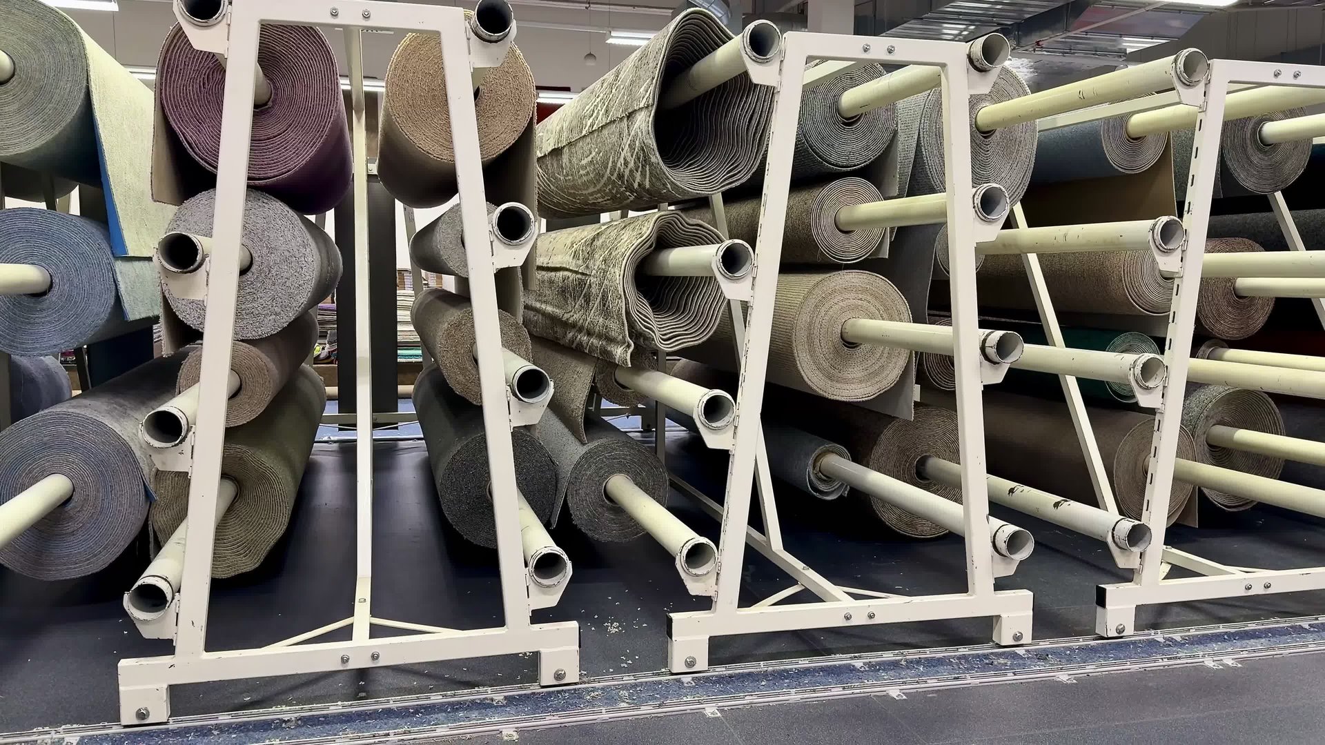 Organized storage of various media rolls on racks, showcasing material diversity in a comprehensive layout.