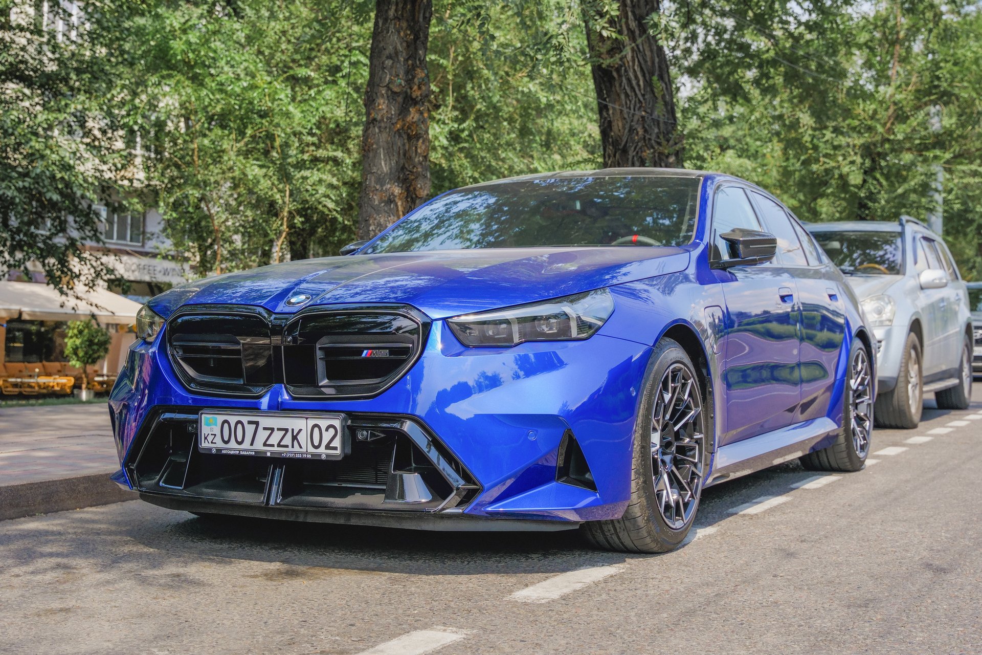 Almaty, Kazakhstan - July 15, 2025: Blue BMW M5 G60 in street parking. Hybrid car