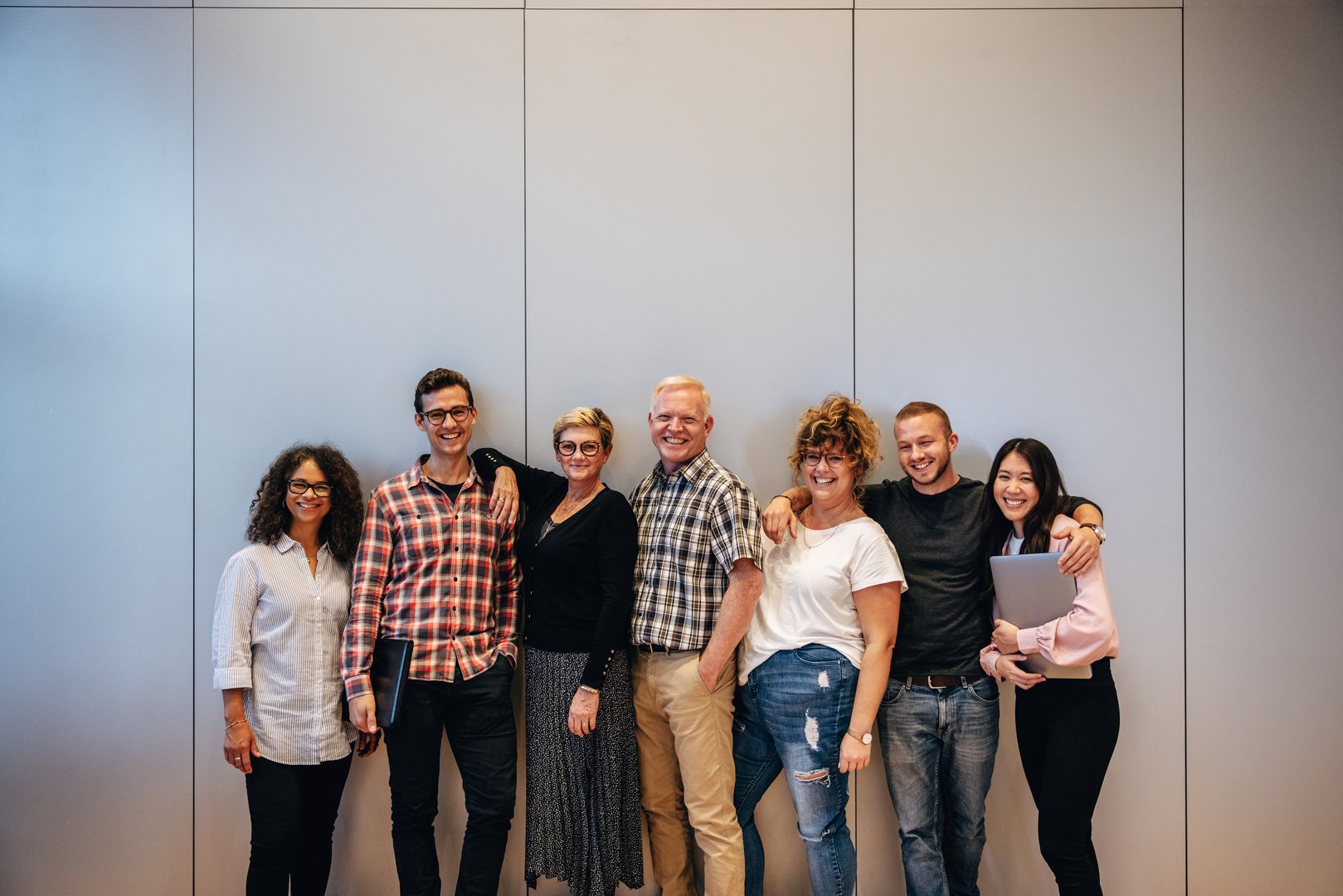 Group of multiracial business professionals standing together. Portrait of a successful business team standing against a wall.
