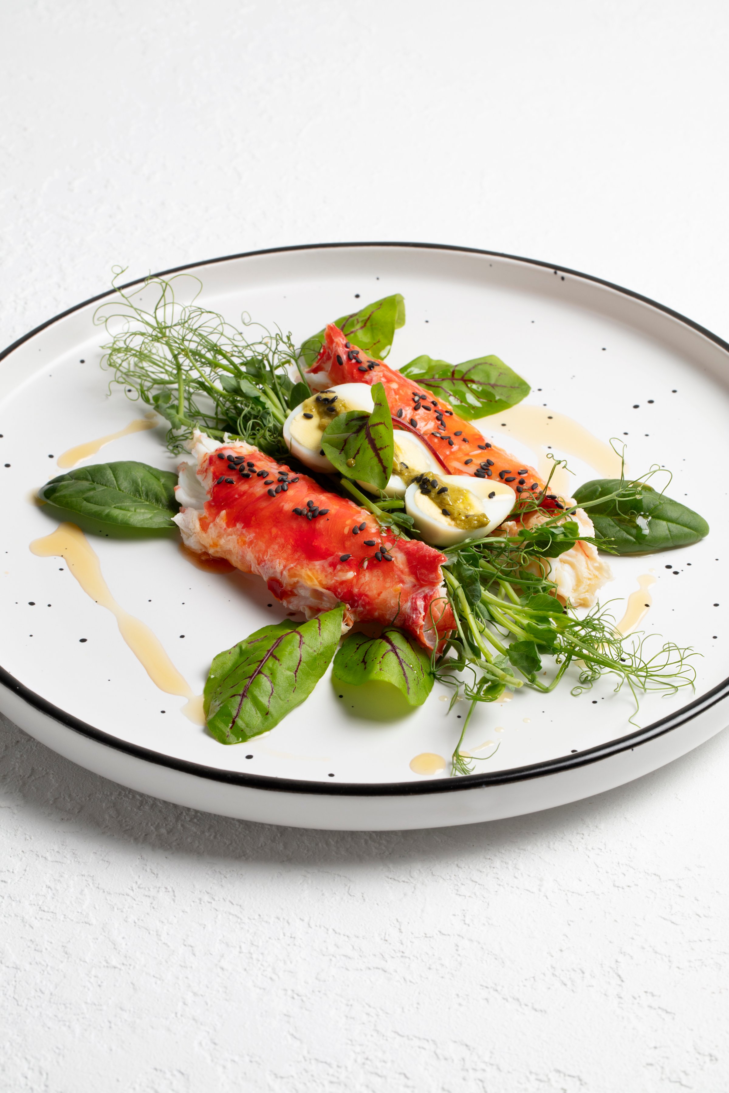 Appetizer with Crab Meat, Quail Eggs, Sesame Oil, Pea Microgreens, and Salad Greens. Healthy Food Concept. Styled Dish, Handmade Photo, Not AI