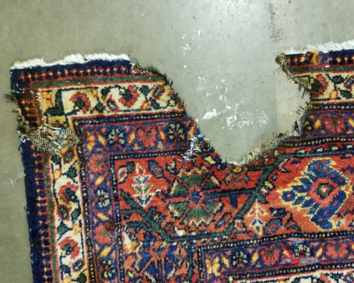 Before: Rug with damage requiring professional repair