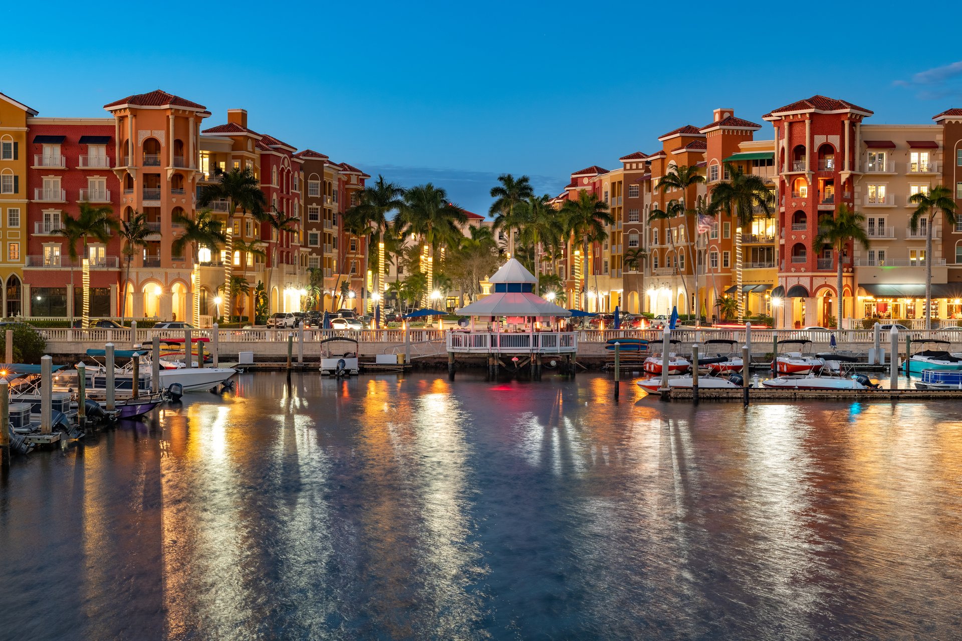 The charming waterfront of Naples, Florida, showcasing its beautiful architecture, bustling marina, and vibrant evening lights.