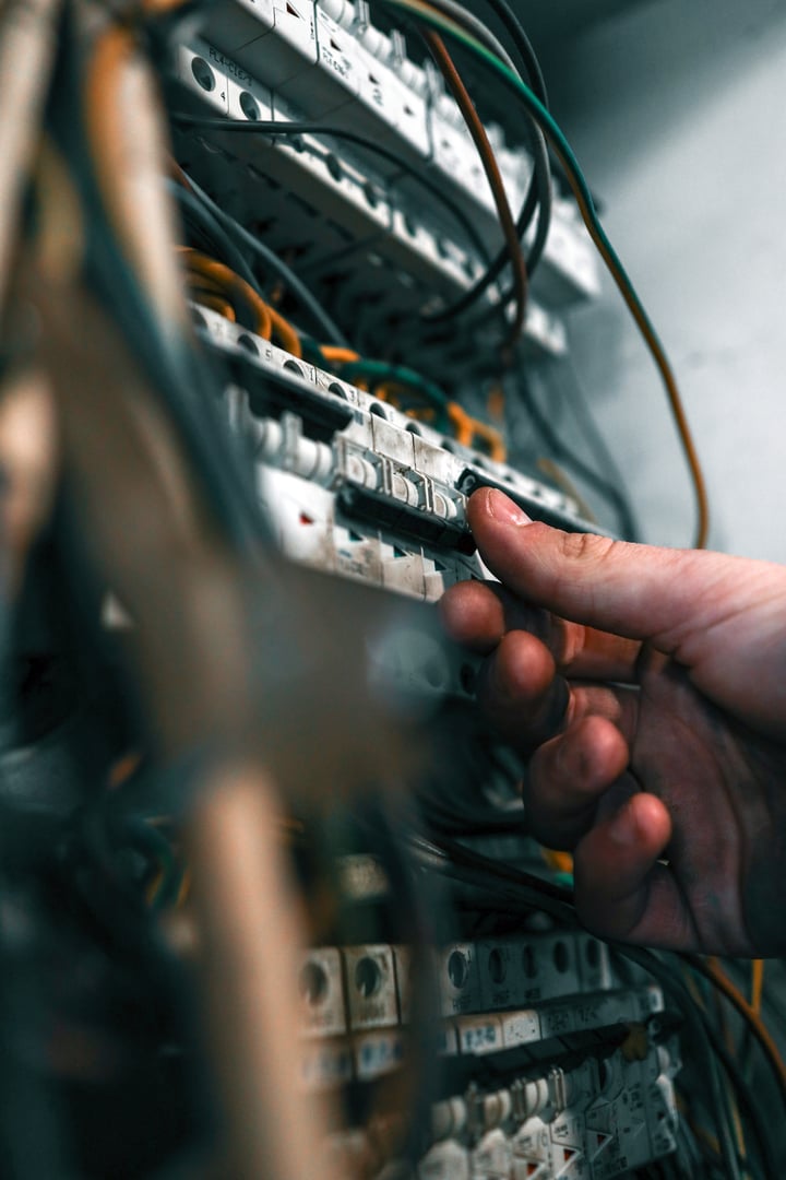 Electrician adjusting wiring in a circuit breaker panel. Concept of electrical maintenance, repair, and professional installation work.