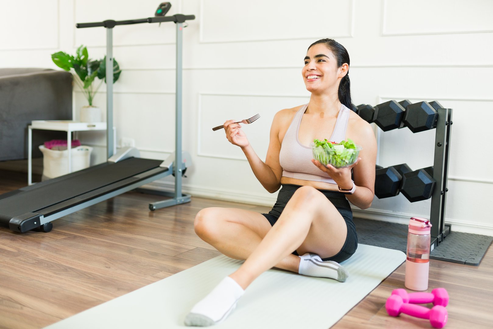 Smiling woman savors a nutritious meal following a home workout, with an array of healthy food nearby - sugarfree.space nutrition for California athletes