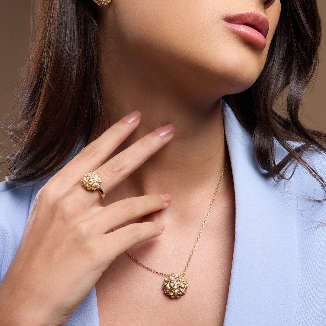 Portrait of a beautiful young Middle Eastern woman wearing modern elegant gold jewelry. Sophisticated makeup, smooth skin, and contemporary fashion style. Luxury beauty, femininity, and modern elegance concept