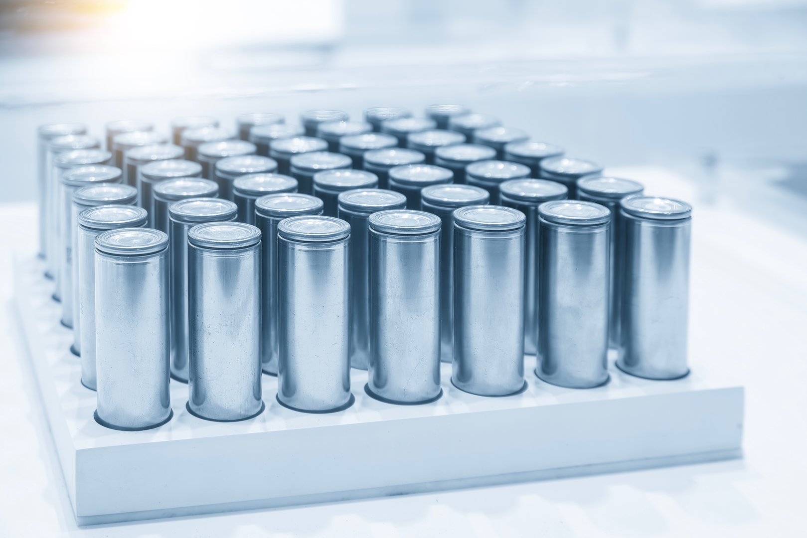 The group of electric vehicle car battery pack in the light blue scene with lighting effect. The battery pack for EV manufacturing concepts.