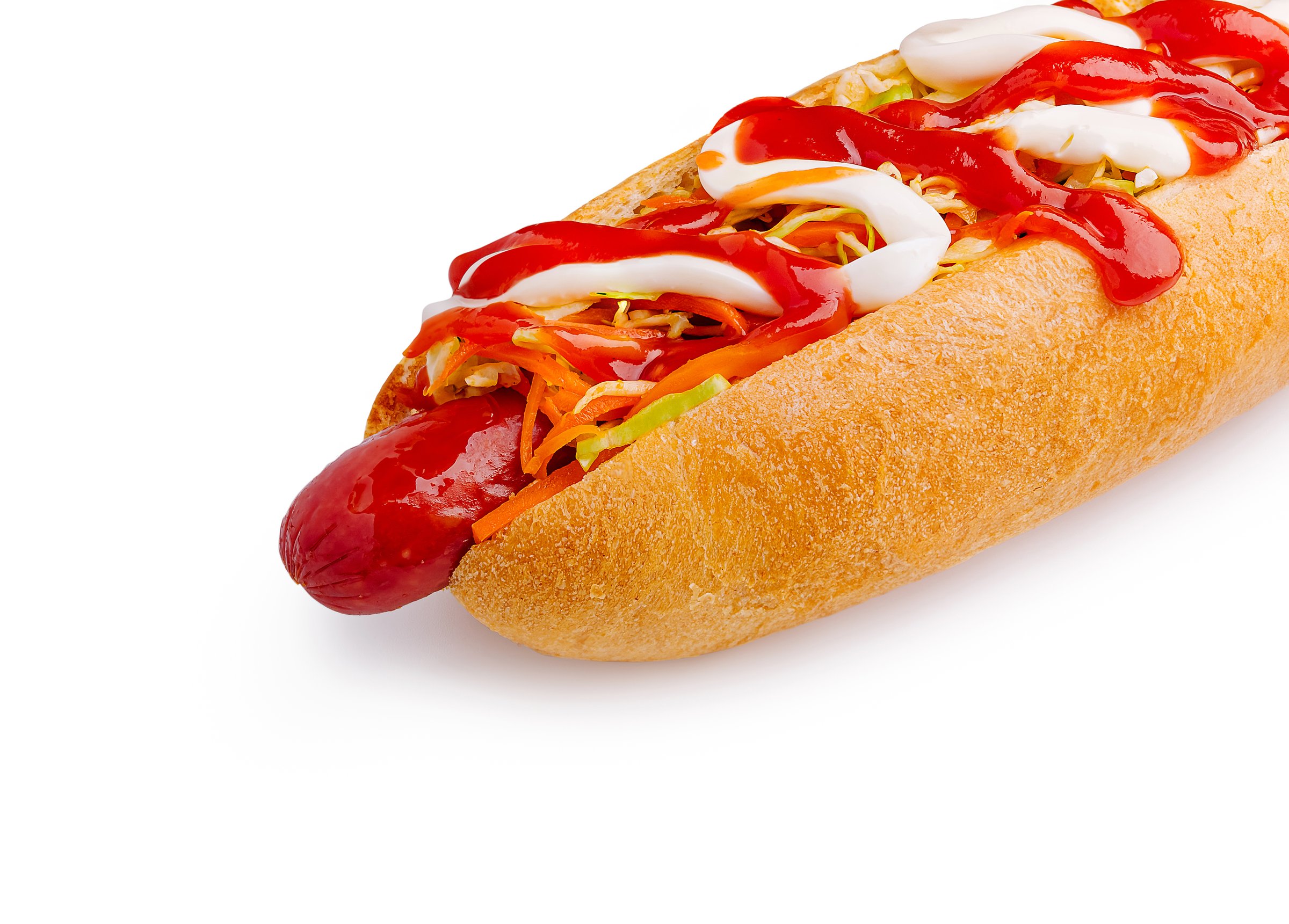 A fresh hot dog bun is filled with a juicy sausage. It is topped with ketchup, mayonnaise, and a mix of colorful vegetables. This classic snack is perfect for casual meals or gatherings.