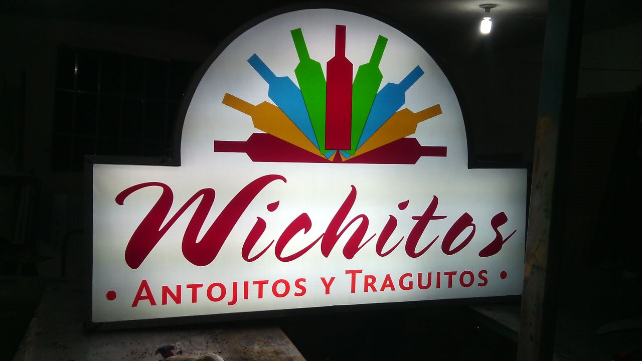 Anuncio luminoso de lona traslúcida en fachada de negocio