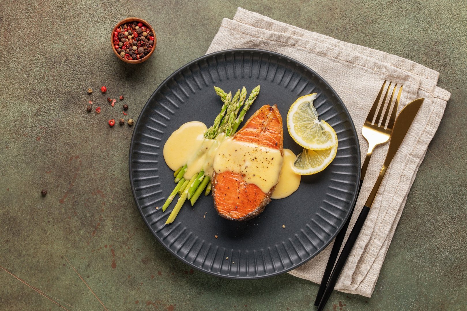 Steak salmon grill with asparagus sprouts, with hollandaise sauce in a plate on the table. Top view