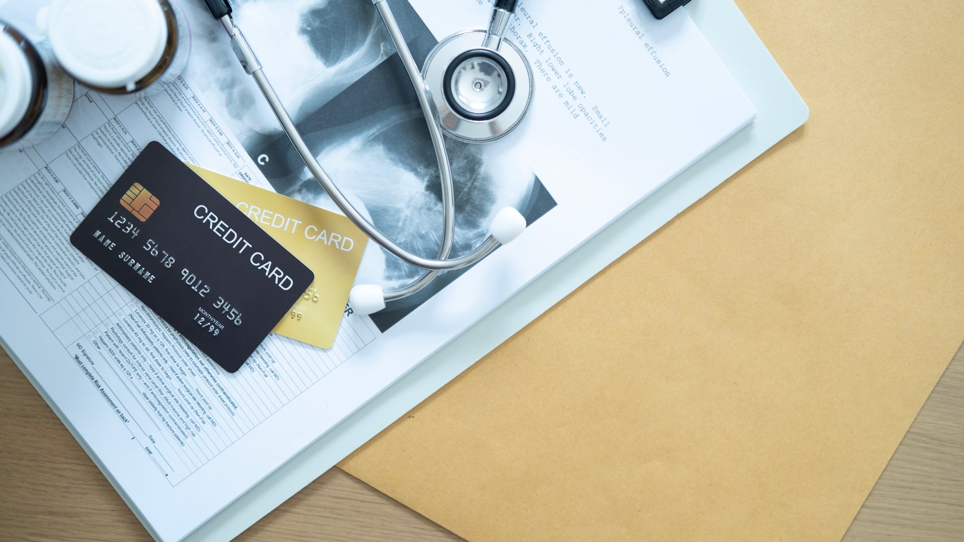Black and gold credit cards on a medical document stack, symbolizing financial tools for health costs.