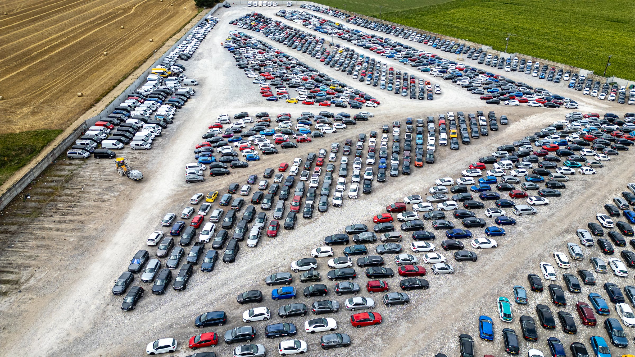 An aerial view showcases a vast outdoor storage lot filled with rows of diverse vehicles  at Copart yard in York, UK.