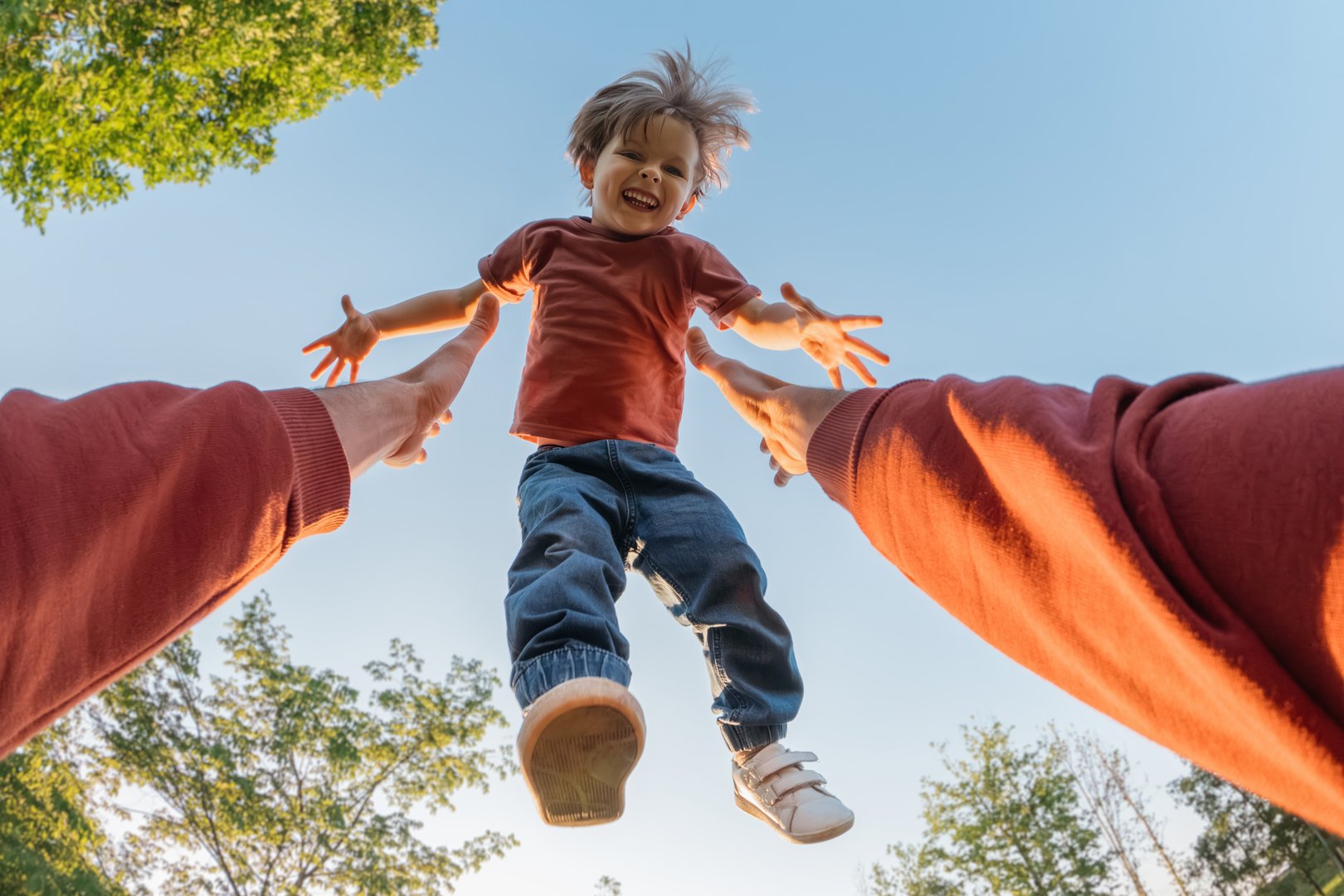 Father throwing son in air in park
