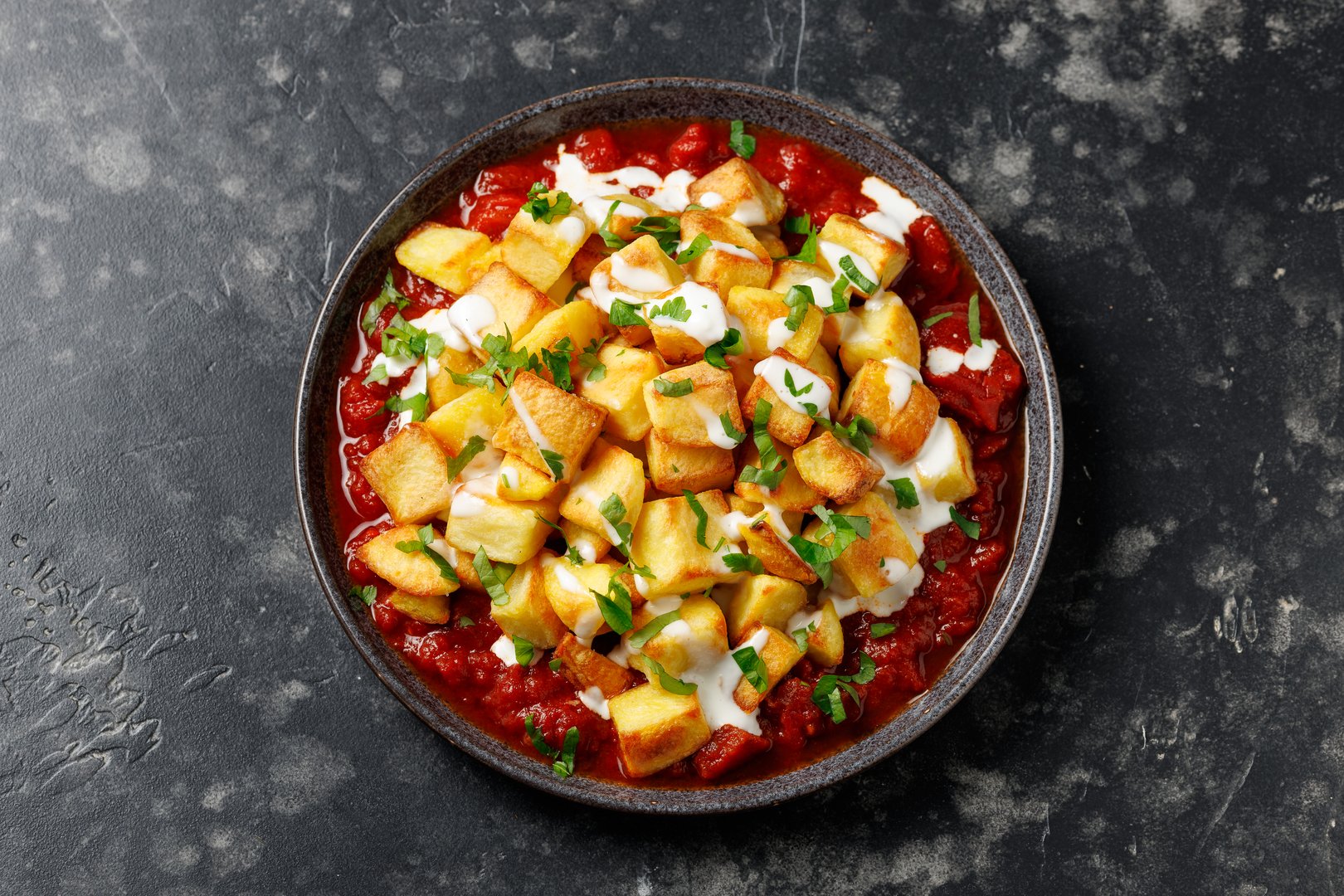 Patatas bravas, spanish deep fried potatoes with spicy sauce and garlic aioli.