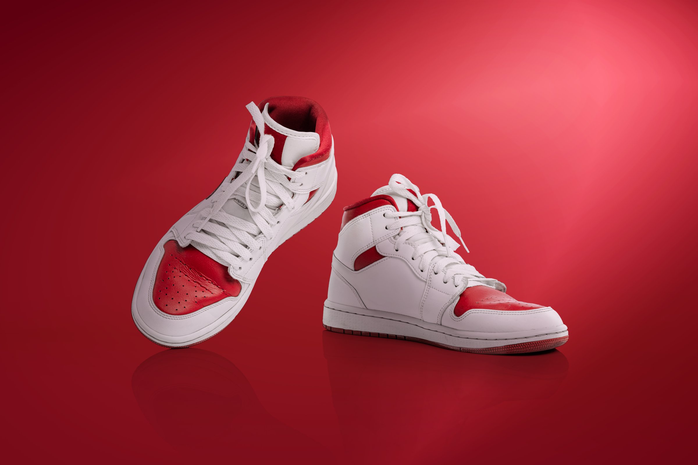 Step by step. Strolling sports shoes on red background. Sneakers or trainers isolated. Athletic shoes. fitness, sport, training concept. Urban fashion. Copy space for ad, text, design