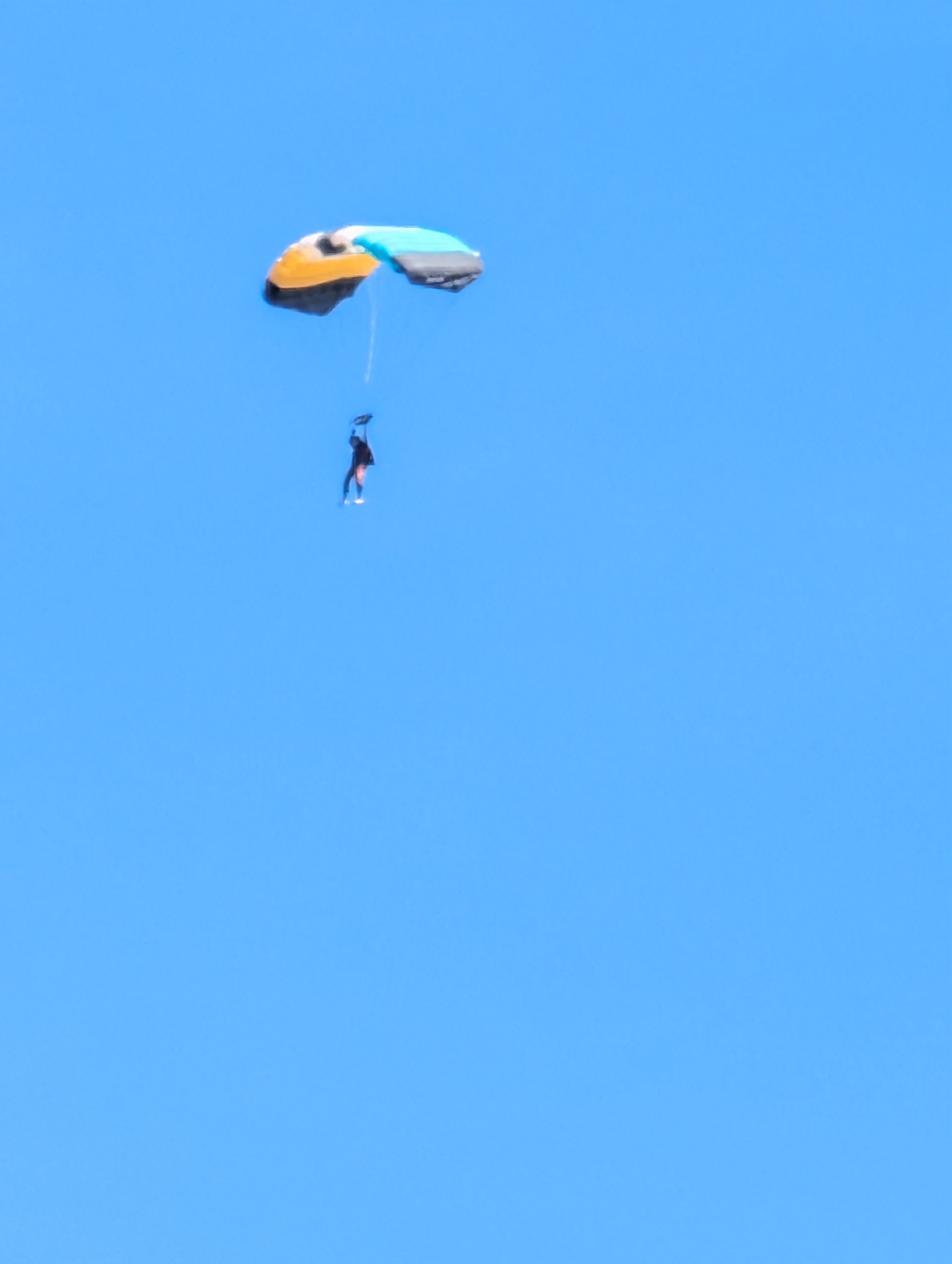 Paracaidista en cielo azul amplio