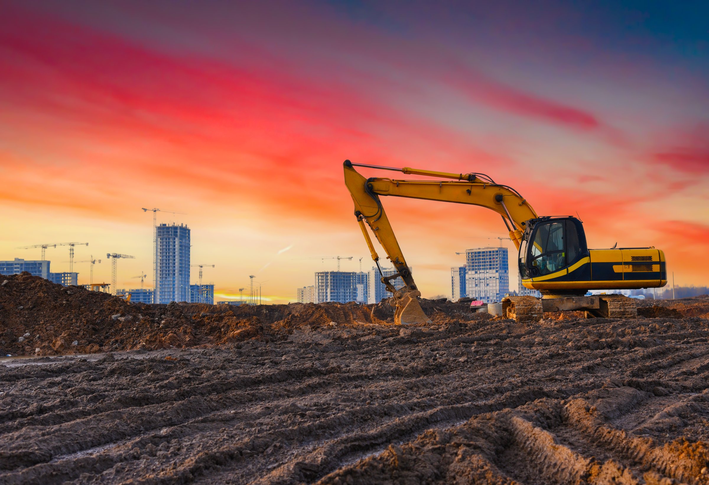 Excavator on construction site. Buildings under construction on sunset. Excavator on groundwork. Backhoe on roadworks. Excavator on earthworks. Heavy machinery equipment on excavation on sunset.