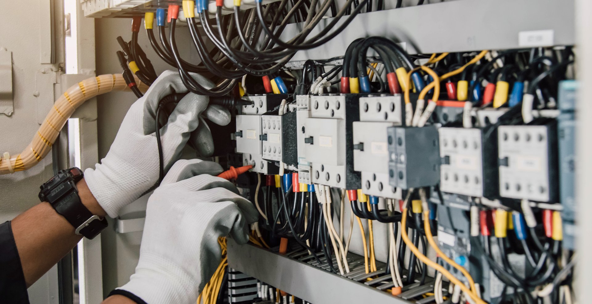 Electrician engineer tests electrical installations and wires on relay protection system.