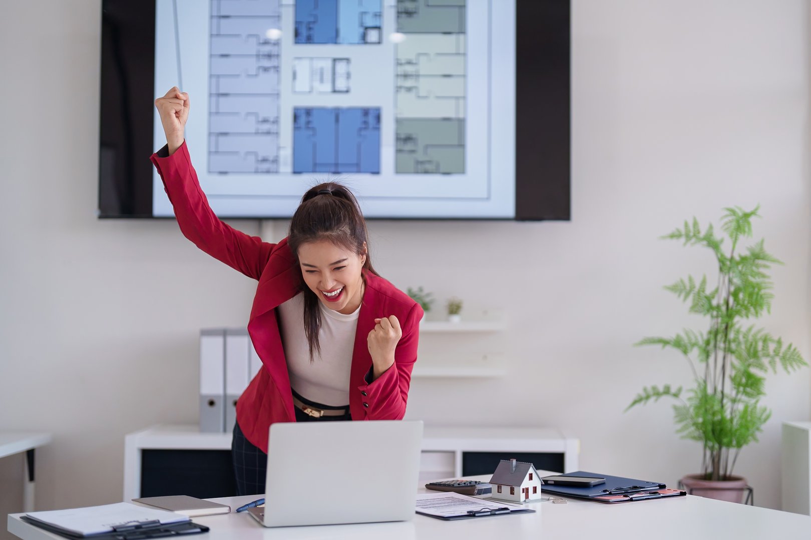 Asian woman professional shows triumph successful real estate business. Architect project achievement. Happy professional in modern office. Property sales triumph.