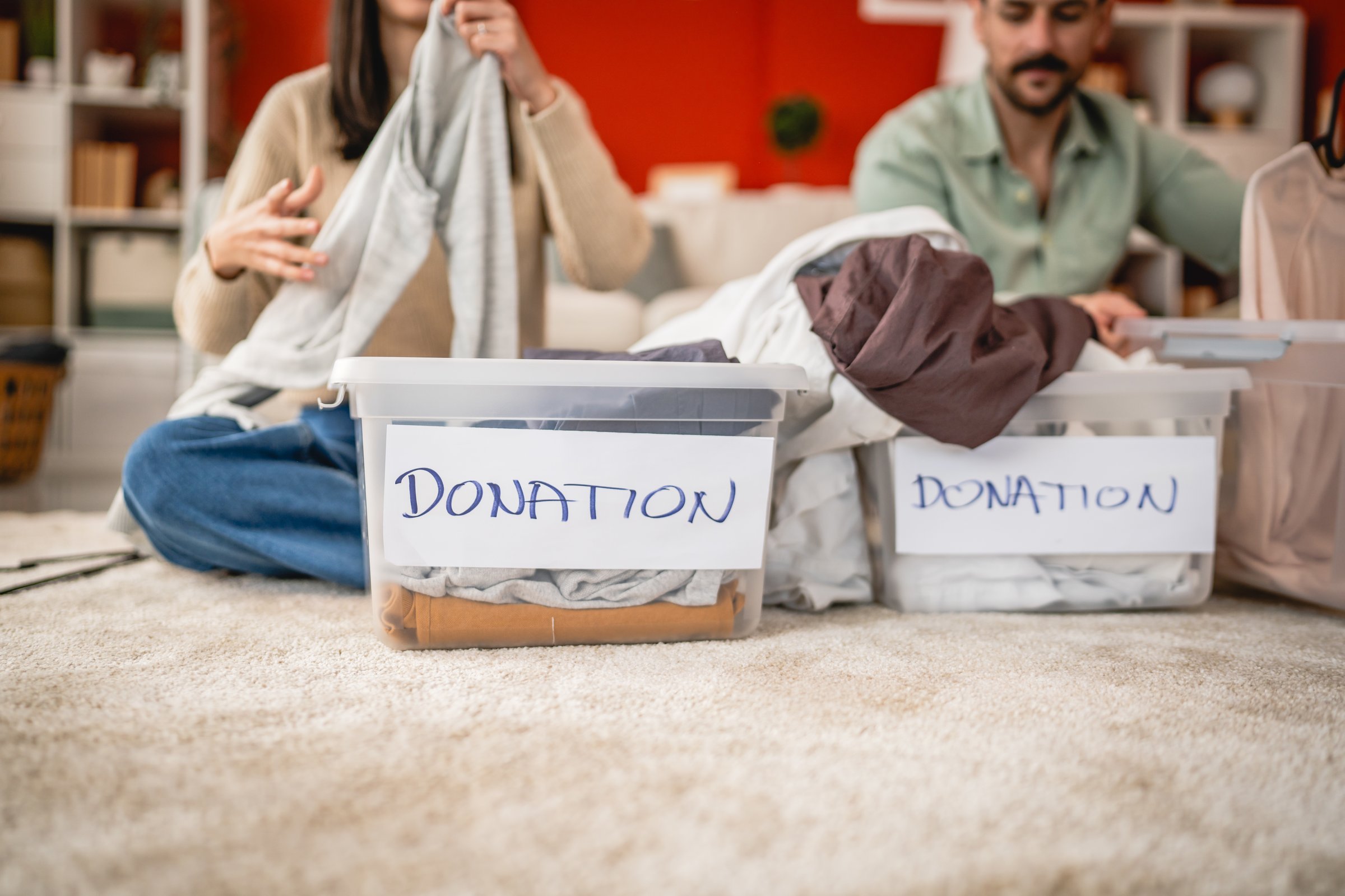close up on clothes in plastic box for donation on the table at home