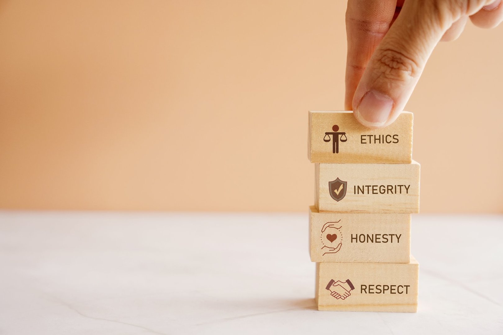 Hand holding wooden block with code of conduct concept, ethics, integrity, honesty, respect.