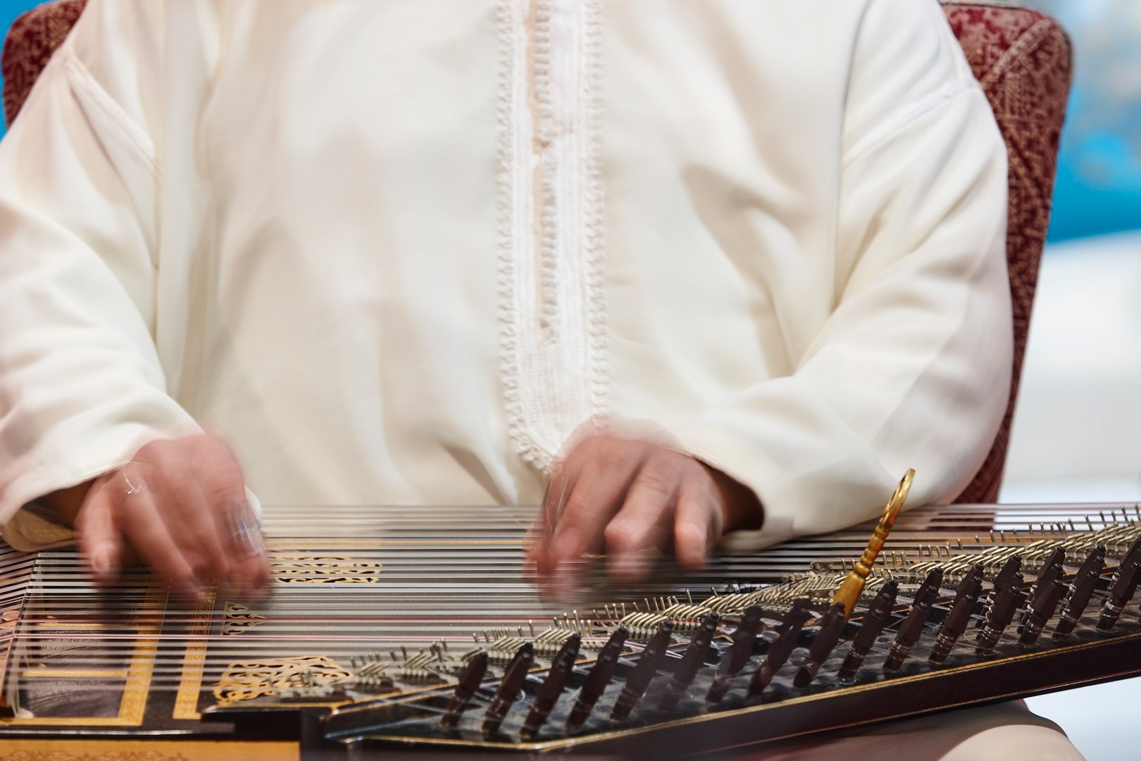 Traditional moroccan musician with wooden string instrument. Qanun
