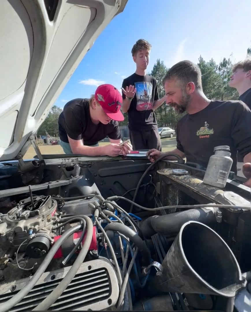 Students learning hands-on mechanics and vehicle restoration