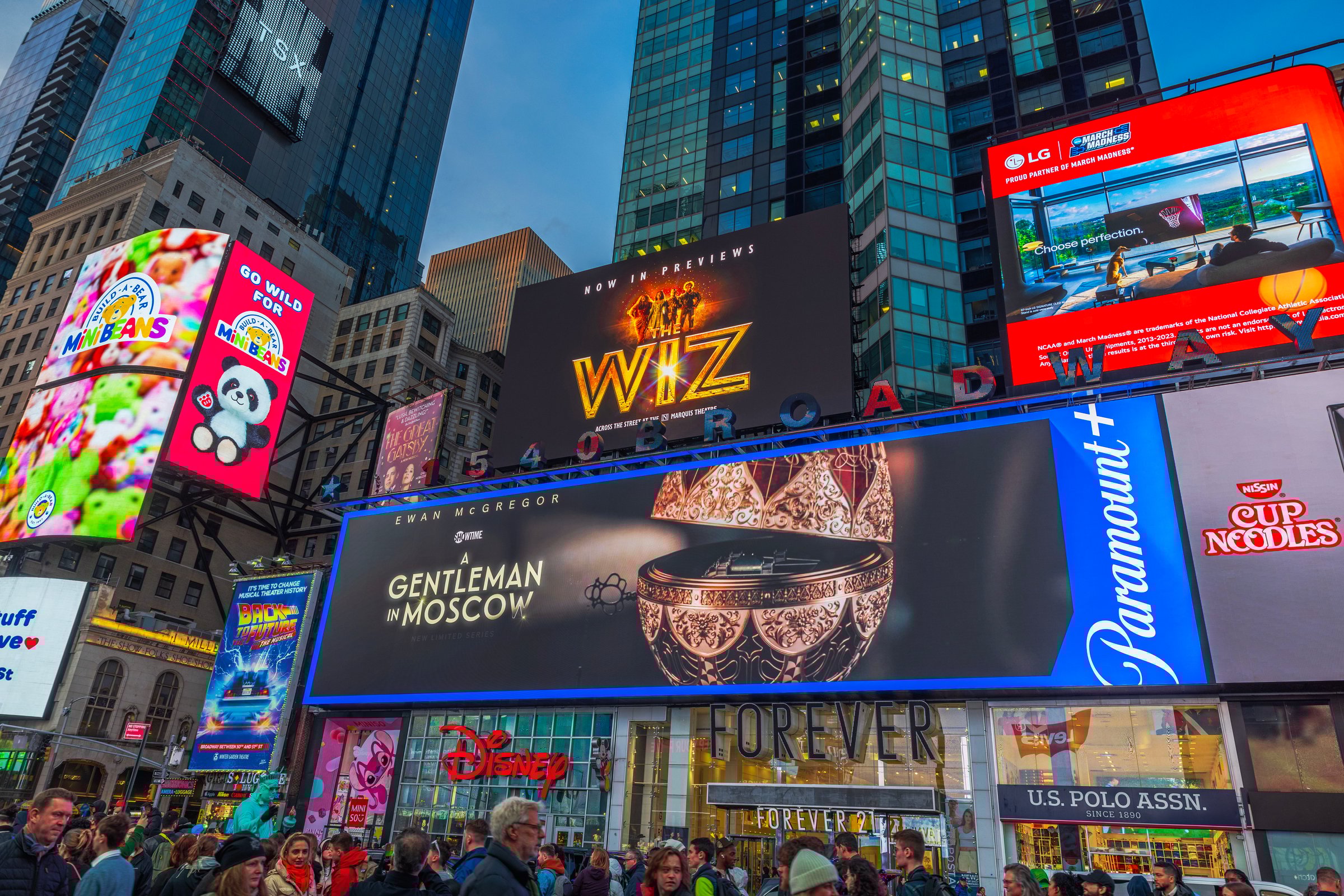 New York. USA. 03.04.2025. Times Square in New York City with illuminated billboards, digital advertisements and bustling crowd in evening.