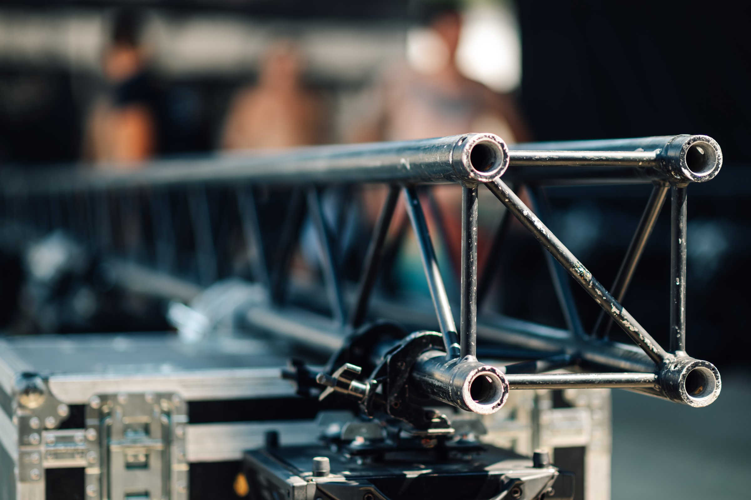 Sturdy metal truss structure lies securely fastened to a flight case, awaiting assembly by stagehands preparing for an upcoming concert or event