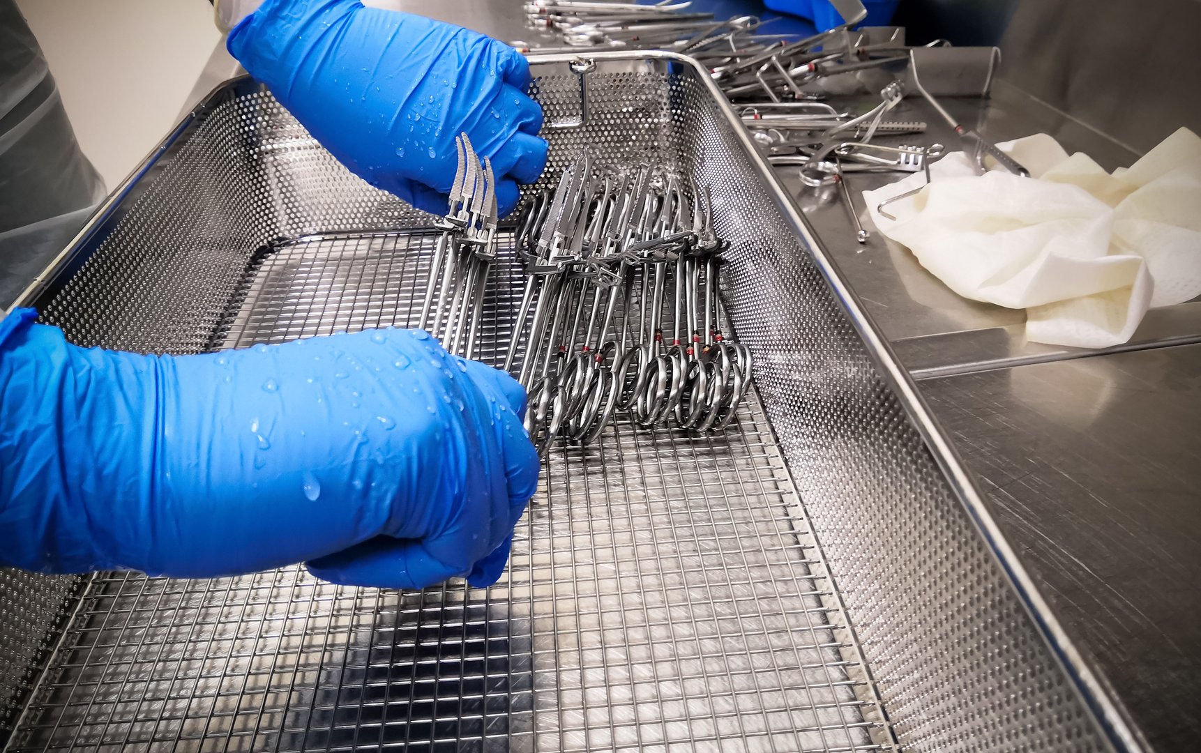 Nurse Cleaning and Arranging Medical Surgical Instrument for Washing and Reprocessing. Nurse Worn Blue Nitrile Gloves