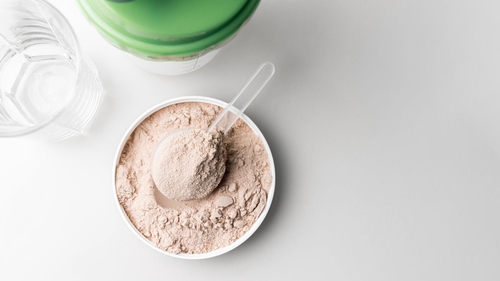 Whey protein powder in measuring scoop, top view.