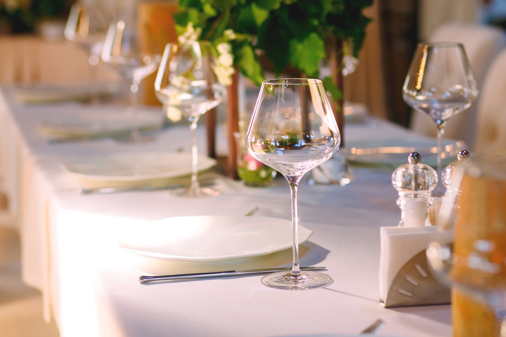 Elegant Restaurant Table Setting Service for Reception with Reserved Card. View of a table with empty wine glasses and plates. Preparing to welcome guests in a restaurant