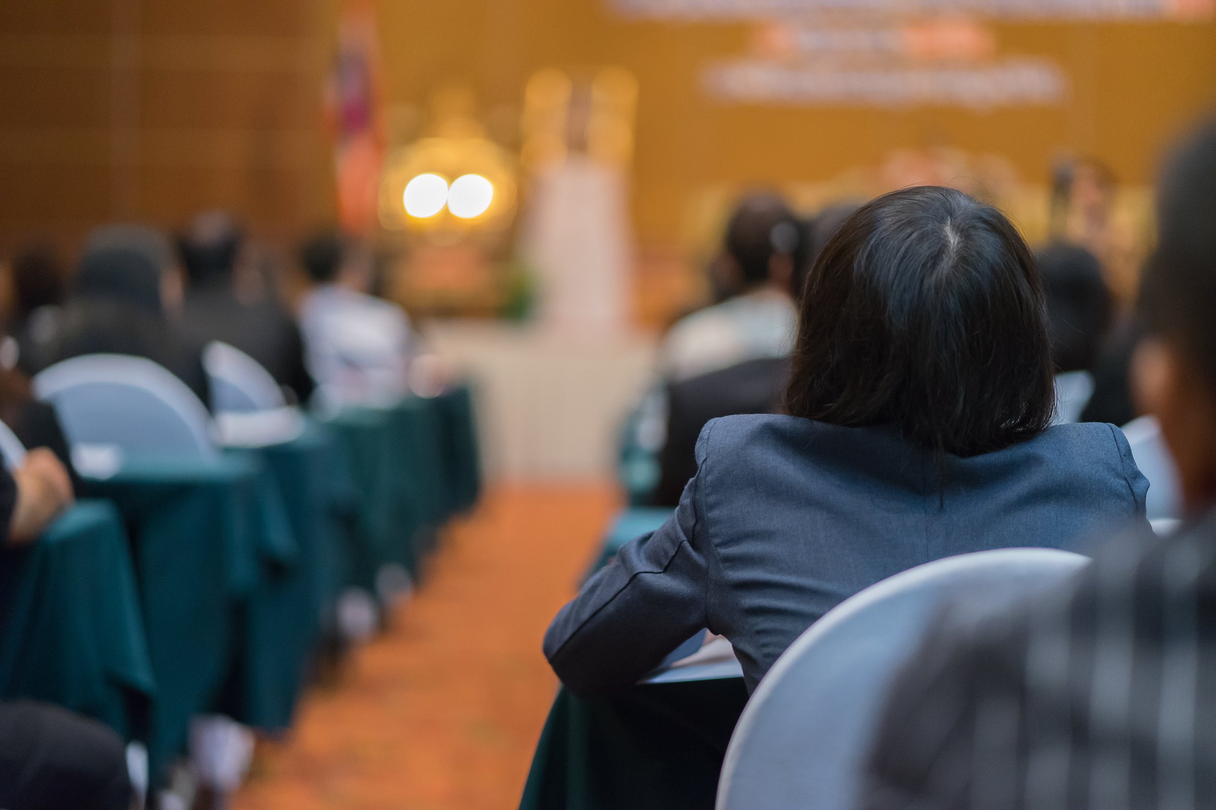 Student listening to Speaker Giving a Talk at Business Meeting