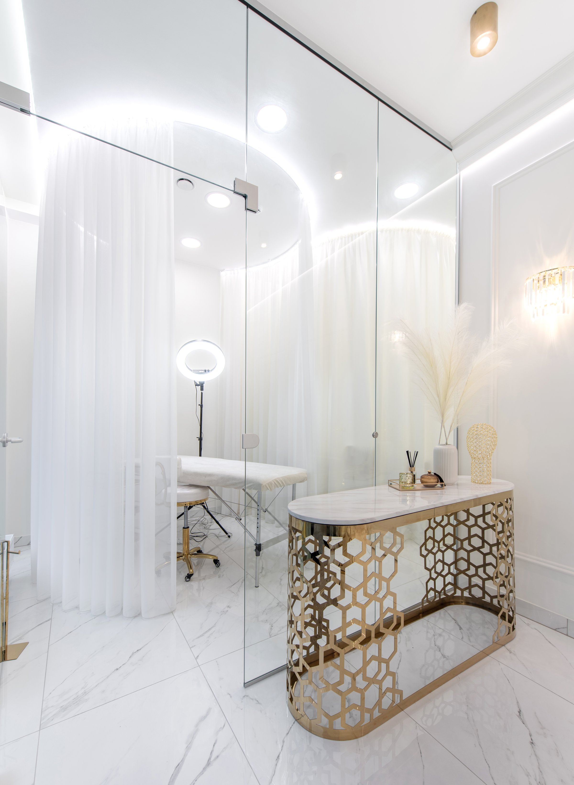 A chic beauty SPA clinic interior featuring gold accent furniture, white curtains, minimalist decor, creating a luxurious serene atmosphere ideal for professional treatment and personal care spaces.