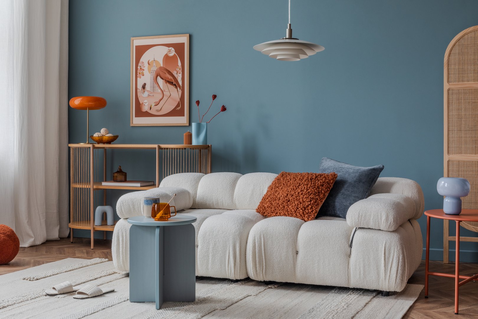 Neutral-toned living room corner with layered textiles, a cushioned sofa, and minimalistic decor for a calm ambiance.