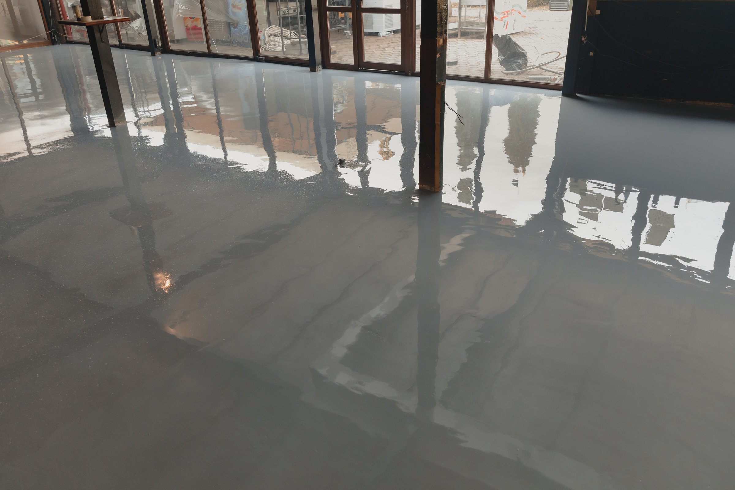 Shiny resin floor reflecting windows in a modern commercial building interior, creating a sleek and polished look