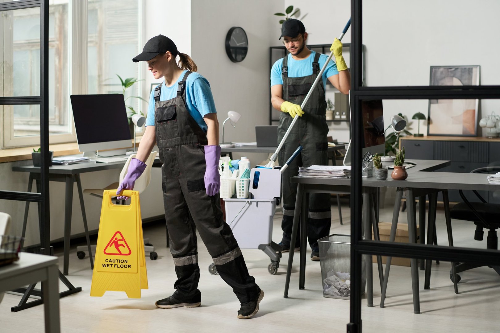Cleaners in uniform cleaning office room in team