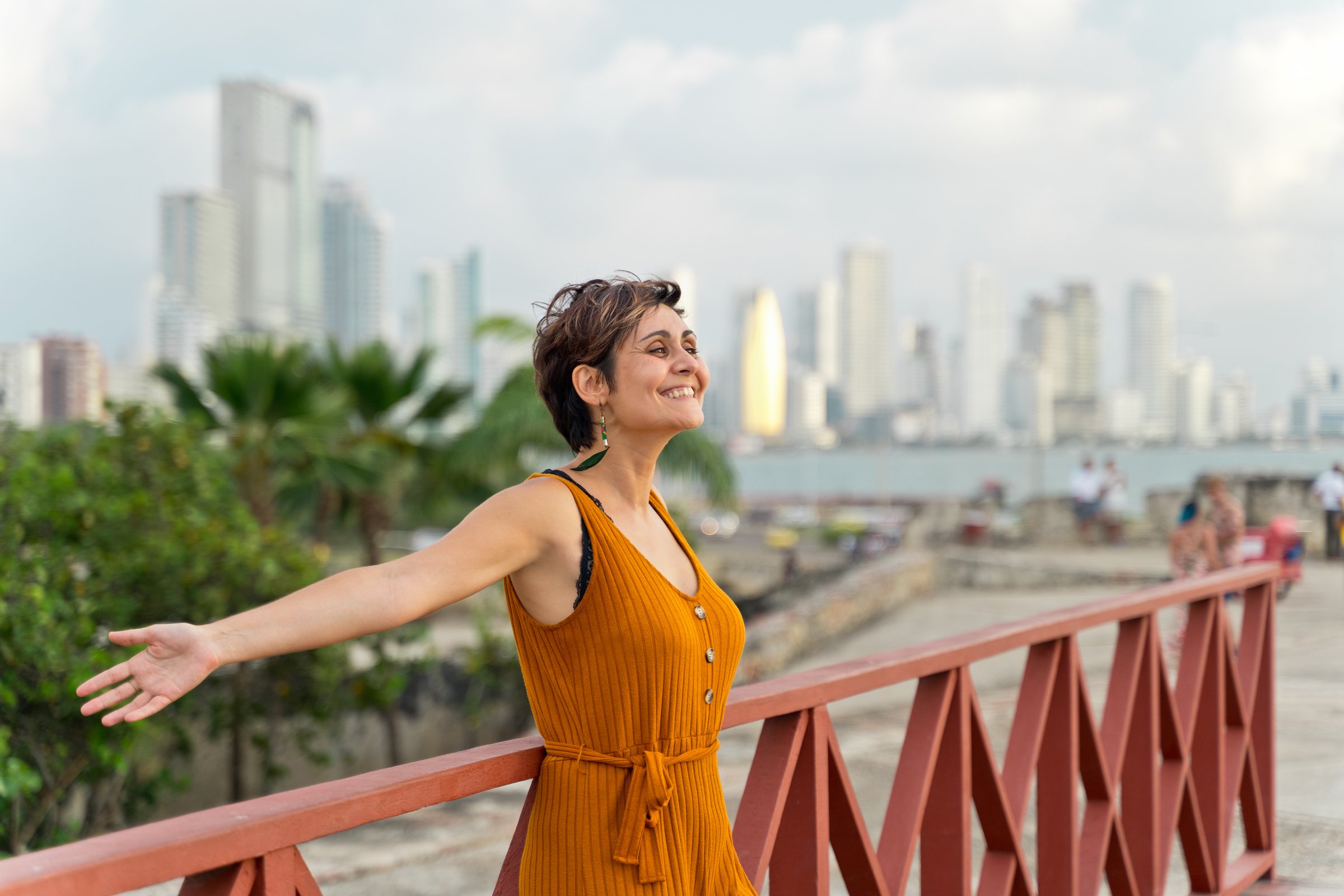 Horizontal view of latin woman sightseeing with Bocagrande skyline in the background. Travel to Colombia concept.
