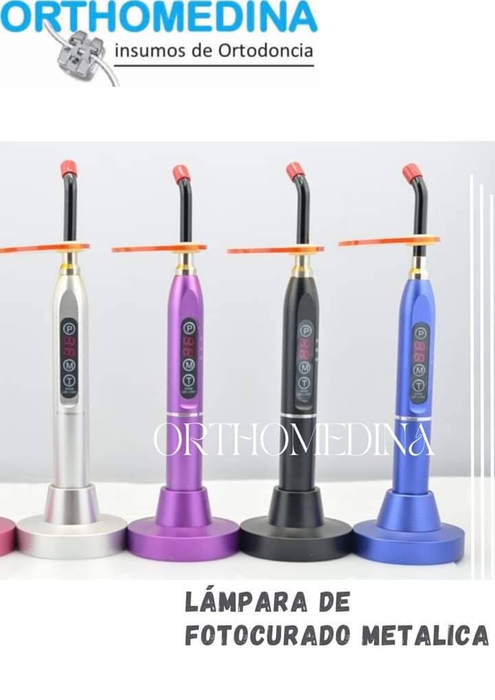 Four metallic dental curing lights in different colors on display stands with ORTHOMEDINA branding.